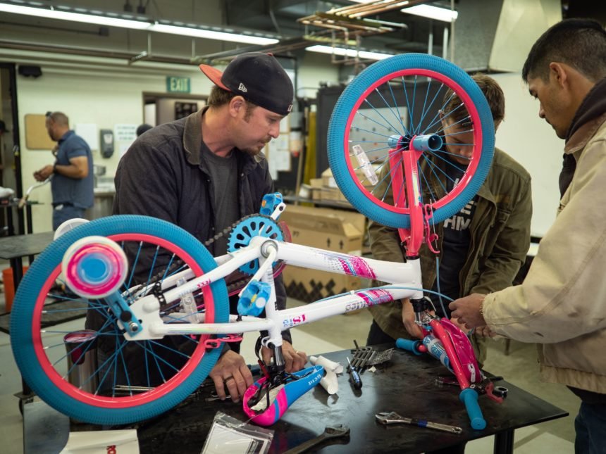 workers building a bike together.
