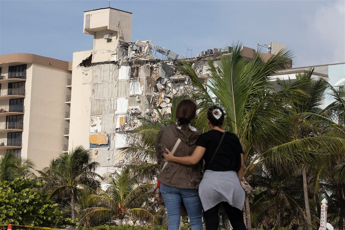 <i>Joe Raedle/Getty Images</i><br/>Maria Fernanda Martinez and Mariana Cordeiro look on as search and rescue operations continue at the site of the partially collapsed 12-story condo building on Friday in Surfsid