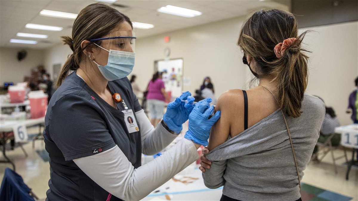 <i>Sergio Flores/Getty Images</i><br/>A young woman gets her second dose of the Moderna Covid-19 vaccine at a vaccination site at a senior center in San Antonio