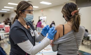 A young woman gets her second dose of the Moderna Covid-19 vaccine at a vaccination site at a senior center in San Antonio