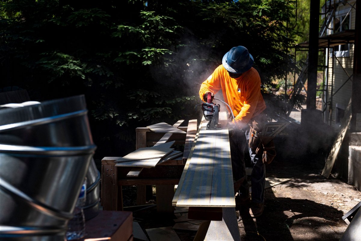 <i>David Paul Morris/Bloomberg/Getty Images</i><br/>A contractor uses a saw to cut siding for a house under construction in Walnut Creek