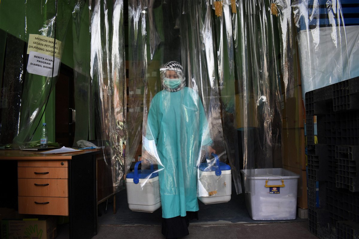 <i>Timur Matahari/AFP/Getty Images</i><br/>A health worker delivers containers of Sinovac vaccines from a cold room in Bandung