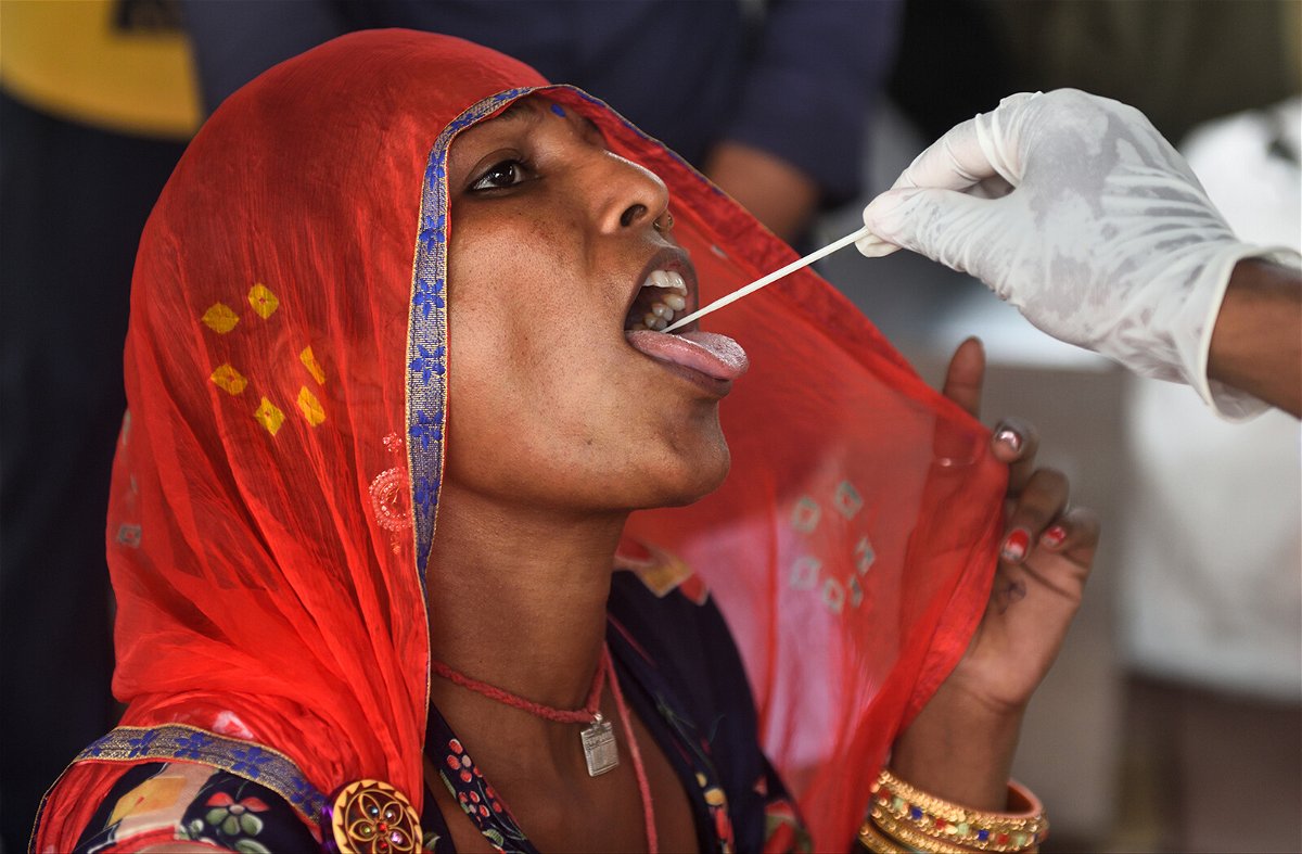 <i>Satish Bate/Hindustan Times/Getty Images</i><br/>A health worker collects a swab sample for a Covid-19 test in Mumbai