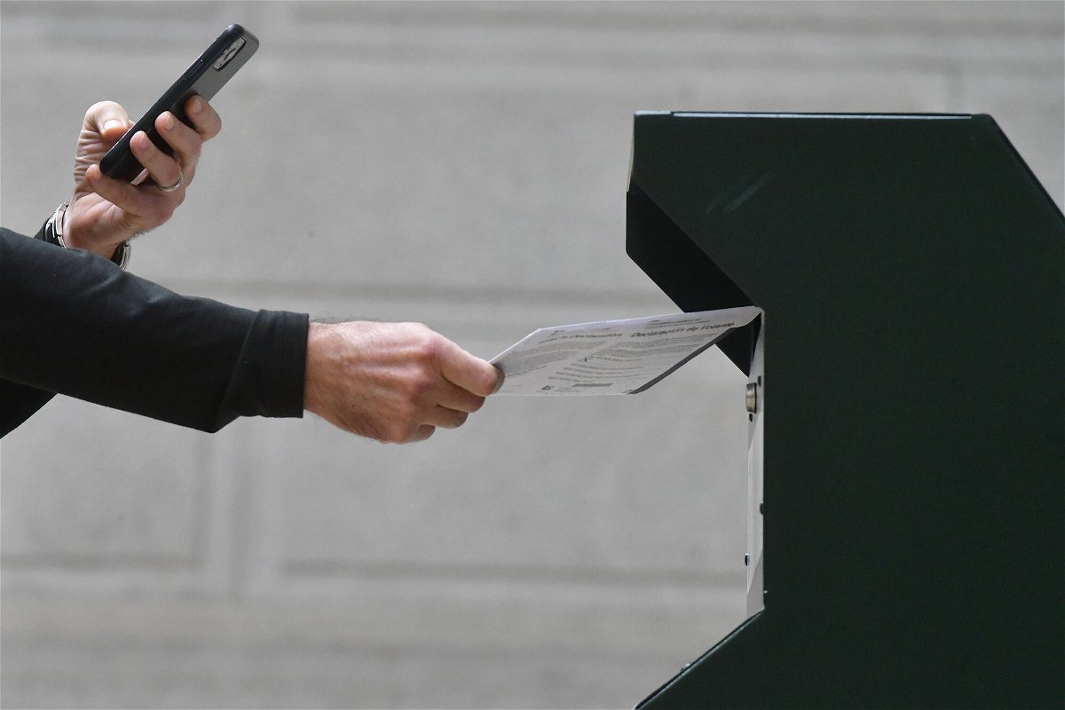 <i>Mark Makela/Getty Images</i><br/>A man deposits his ballot at the satellite polling station on October 27