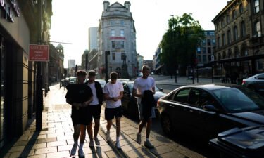 Friends walk along a street in Newcastle on July 19 the day England dropped almost all Covid-19 restrictions.