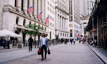 A pedestrian passes by the New York Stock Exchange (NYSE) building in New York