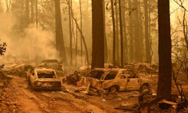 Burned vehicles smolder at a property during the Dixie fire in the Indian Falls area of unincorporated Plumas County.