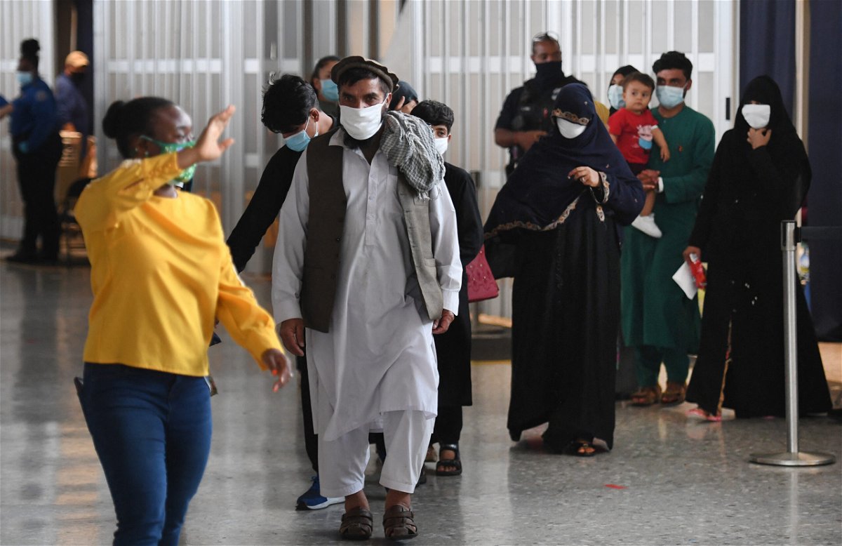 <i>OLIVIER DOULIERY/AFP/AFP via Getty Images</i><br/>Afghan refugees arrive at Dulles International Airport on August 27 in Dulles