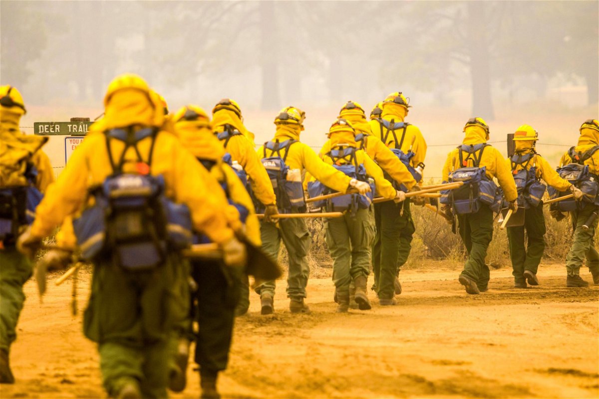 <i>Ty O'Neil/SOPA Images/Sipa</i><br/>Firefighting hand crews walk towards the fire line of the Dixie Fire on August 21.