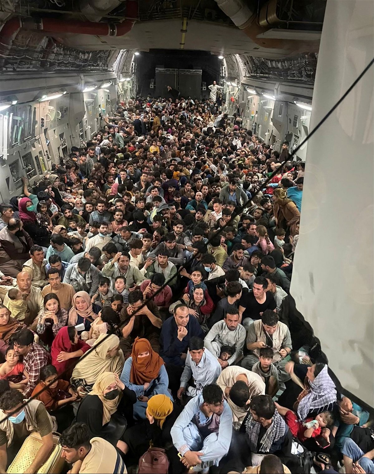 <i>Courtesy of Defense One/Reuters</i><br/>Afghan evacuees crowd the interior of a U.S. Air Force C-17 transport aircraft on its way from Kabul to Qatar on August 15.