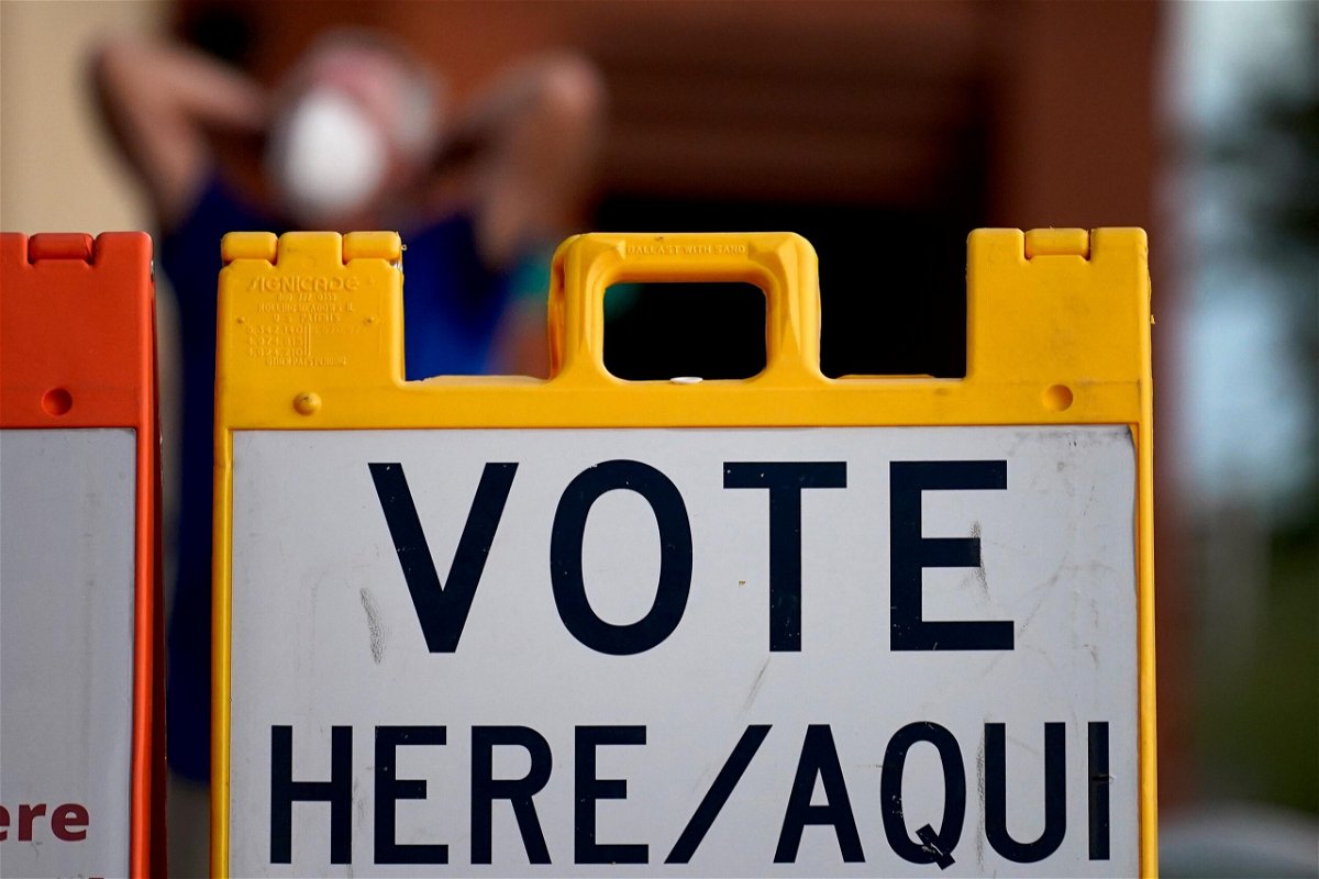 <i>Matt York/AP</i><br/>A poll observer stretches outside a polling station on Election Day