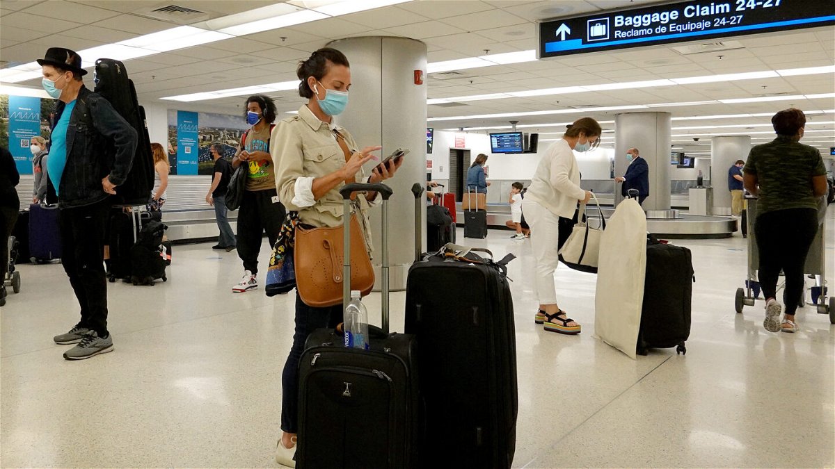 <i>Joe Raedle/Getty Images</i><br/>Travelers gather their luggage as they arrive at Miami International Airport on September 20.