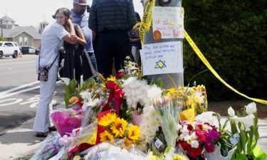 Mourners and well-wishers leave flowers and signs at a makeshift memorial across the street from the Chabad of Poway Synagogue on April 28