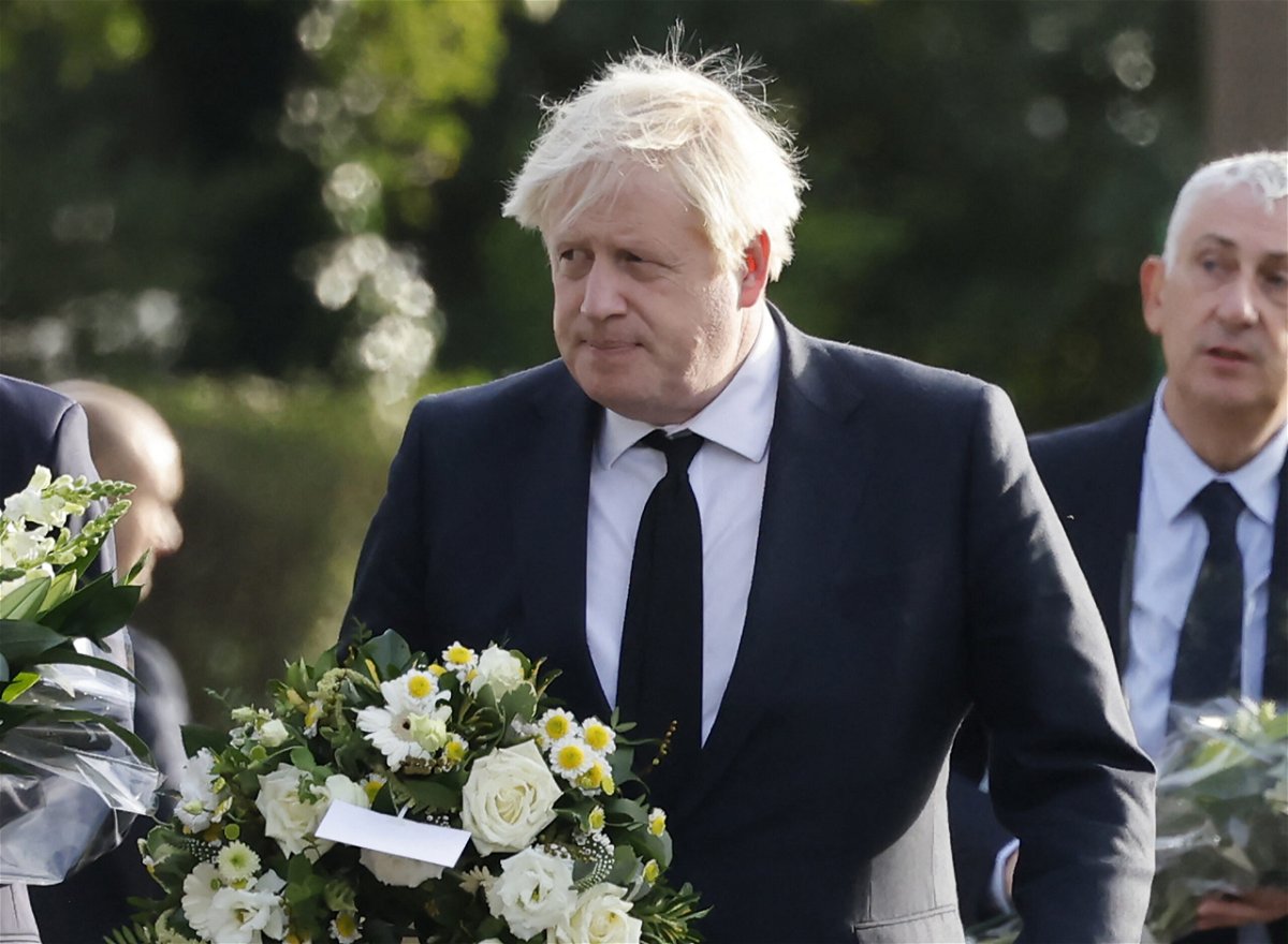 <i>TOLGA AKMEN/AFP/AFP via Getty Images</i><br/>Britain's Prime Minister Boris Johnson carries a floral tribute on arrival at the scene of the fatal stabbing of Conservative British lawmaker David Amess