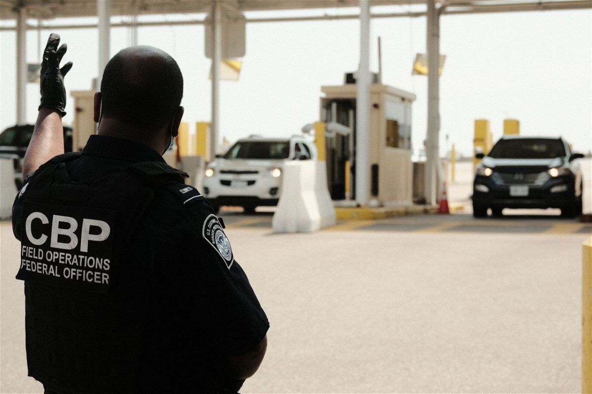 <i>Matthew Hatcher/Getty Images</i><br/>The United States plans to ease restrictions on travel for fully vaccinated visitors from Canada and Mexico starting in early November. U.S. Customs and Border Protection agents are shown directing vehicles re-entering the U.S. from Canada at the Ambassador Bridge Port of Entry August 9