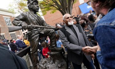 Sculptor Joe Howard shakes hands with people who came to see the unveiling of his statue honoring Black men who enlisted in the US Colored Troops.