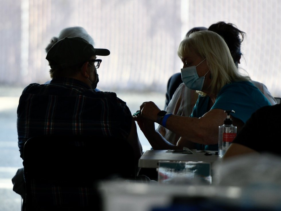 Santa Barbara County Public Health nurse Kathy Clerkin gives a veteran flu vaccine. 