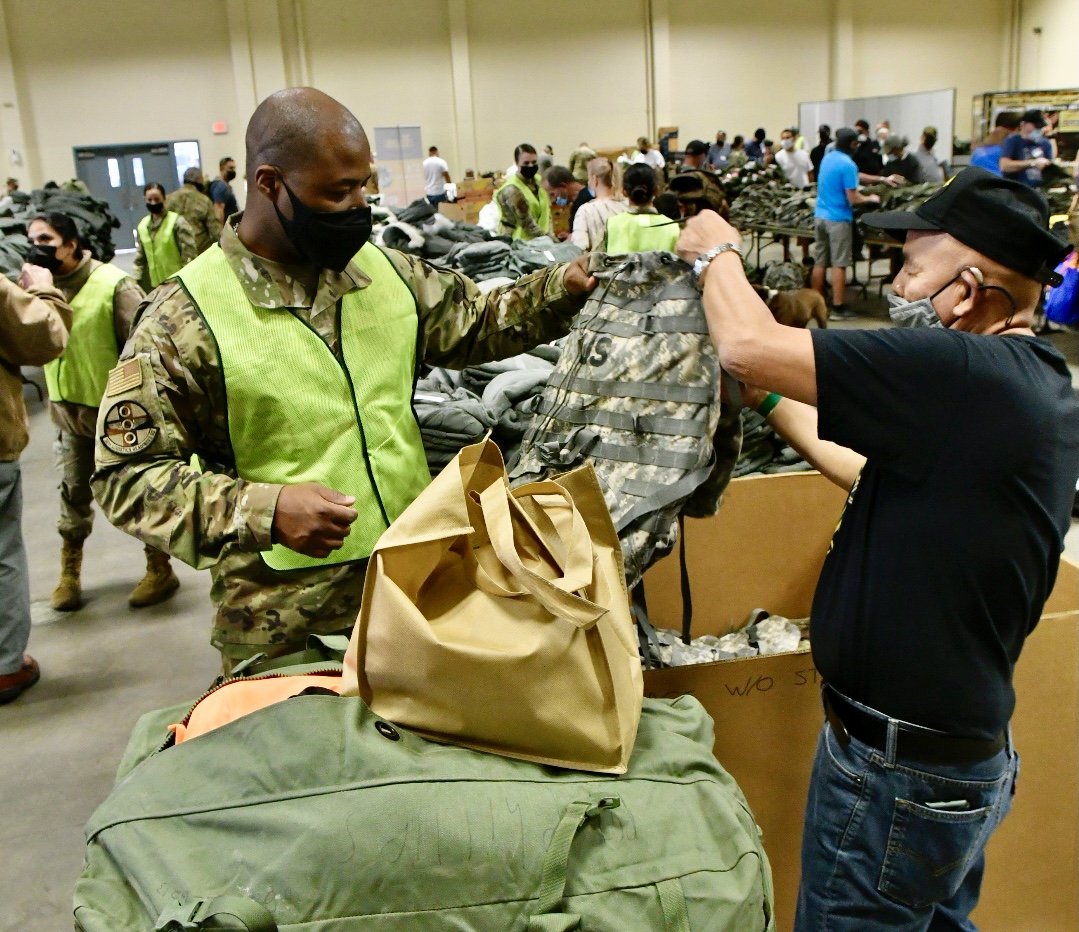 Veteran Basilio Gonzaga chooses a bag with the help of Air Force Tech Sgt.  Marc Warner. 