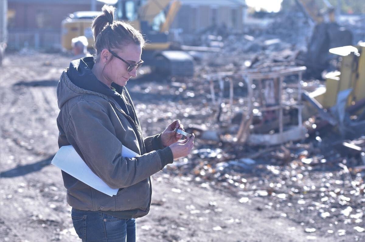 <i>The Journal Times</i><br/>Co-owner Sarah Vassh of Vassh Excavating & Grading Inc. on Tuesday afternoon examines a POW/MIA bracelet her employee Sam DuVall found among the rubble of 1500 N. Memorial Drive. The name on the bracelet is James K. Patterson and Vassh Excavating is hoping to connect the bracelet with its owner.