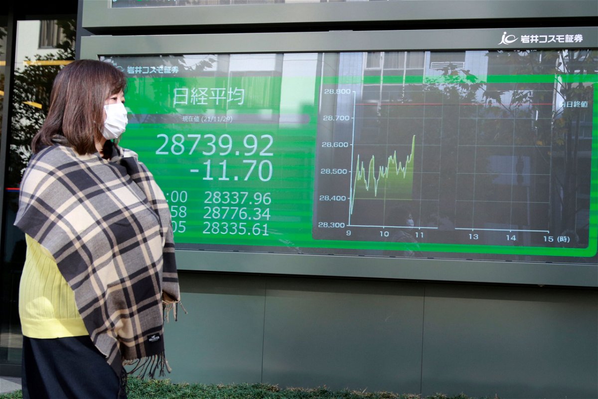 <i>Koji Sasahara/AP</i><br/>A woman walks by an electronic stock board of a securities firm in Tokyo