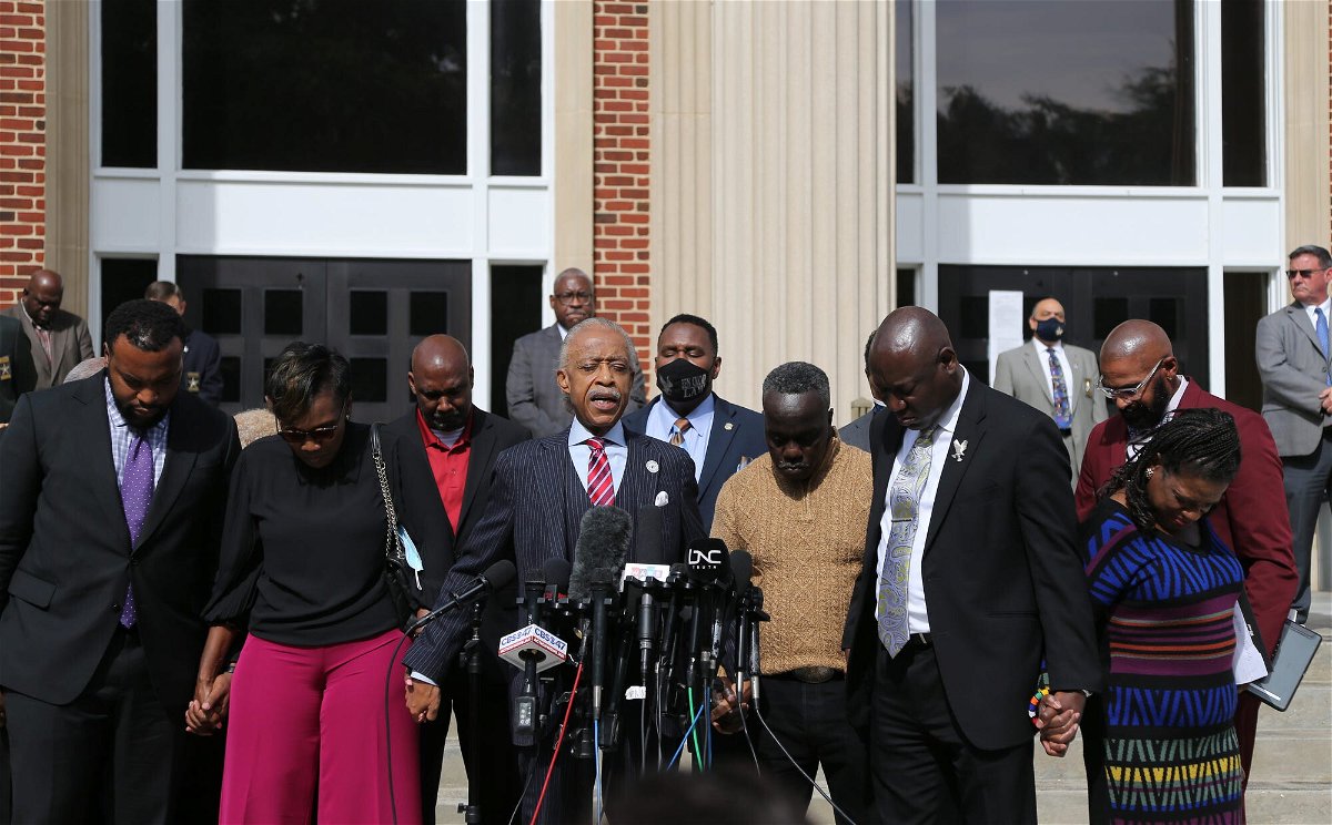 <i>Richard Burkhart/Savannah Morning News /USA Today Network</i><br/>Rev. Al Sharpton (center) prays with Wanda Cooper-Jones and Marcus Arbery in front of the Glynn County Courthouse on November 10.