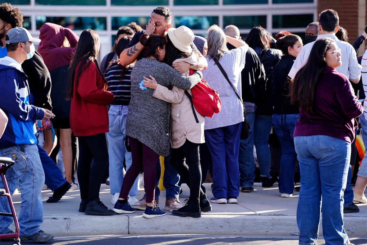 <i>Philip B. Poston/Sentinel Colorado/AP</i><br/>Parents reunite with their children outside of Hinkley High School in Aurora