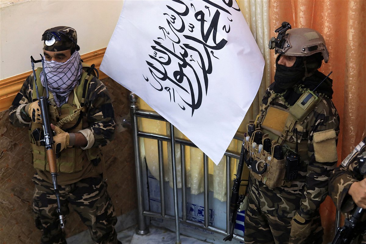 The United States and other countries are 'deeply concerned by reports of summary killings' in Afghanistan. Pictured are Taliban fighters standing guard next to a Taliban flag in Kabul on November 25.