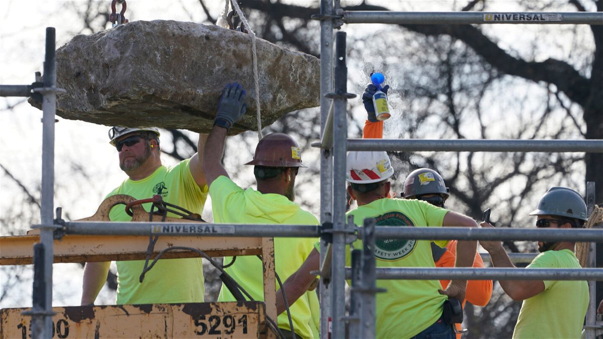 <i>Steve Helber/AP</i><br/>Workers guide a stone containing a time capsule that was placed in 1887.