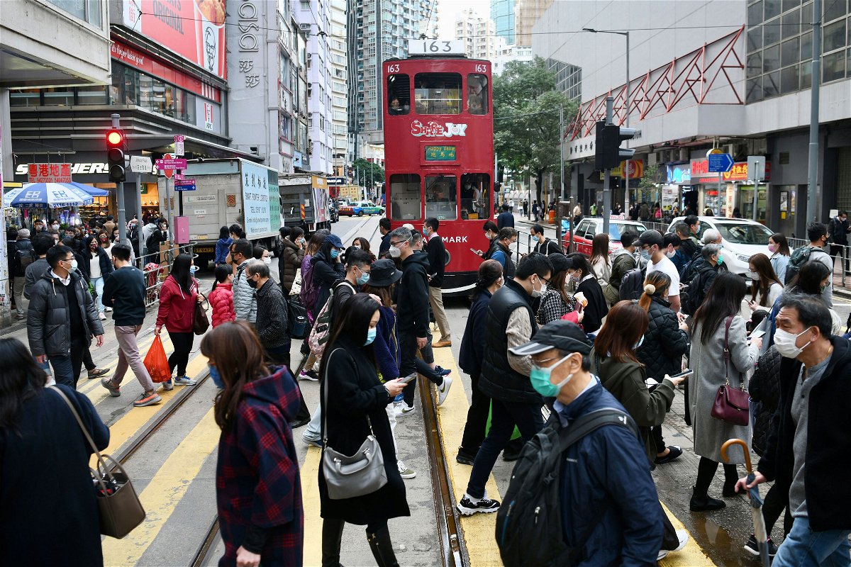 <i>Li Zhihua/China News Service/Getty Images</i><br/>People wearing face masks cross a street in Hong Kong on December 21.