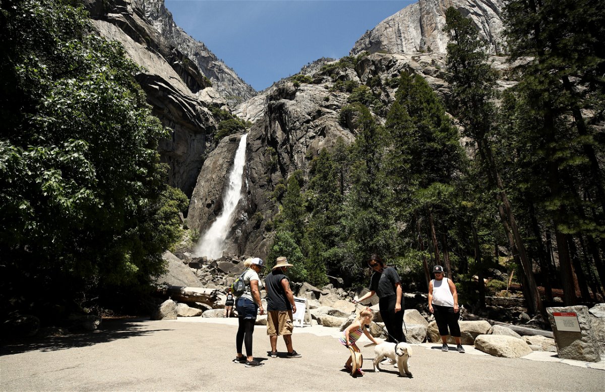 <i>Ezra Shaw/Getty Images</i><br/>Visitors admire the view of Yosemite Falls in the distance. California's Yosemite National Park is so popular during peak summer season that it's now testing a pilot program for campers: A winter lottery in which winners get a chance to make early reservations.