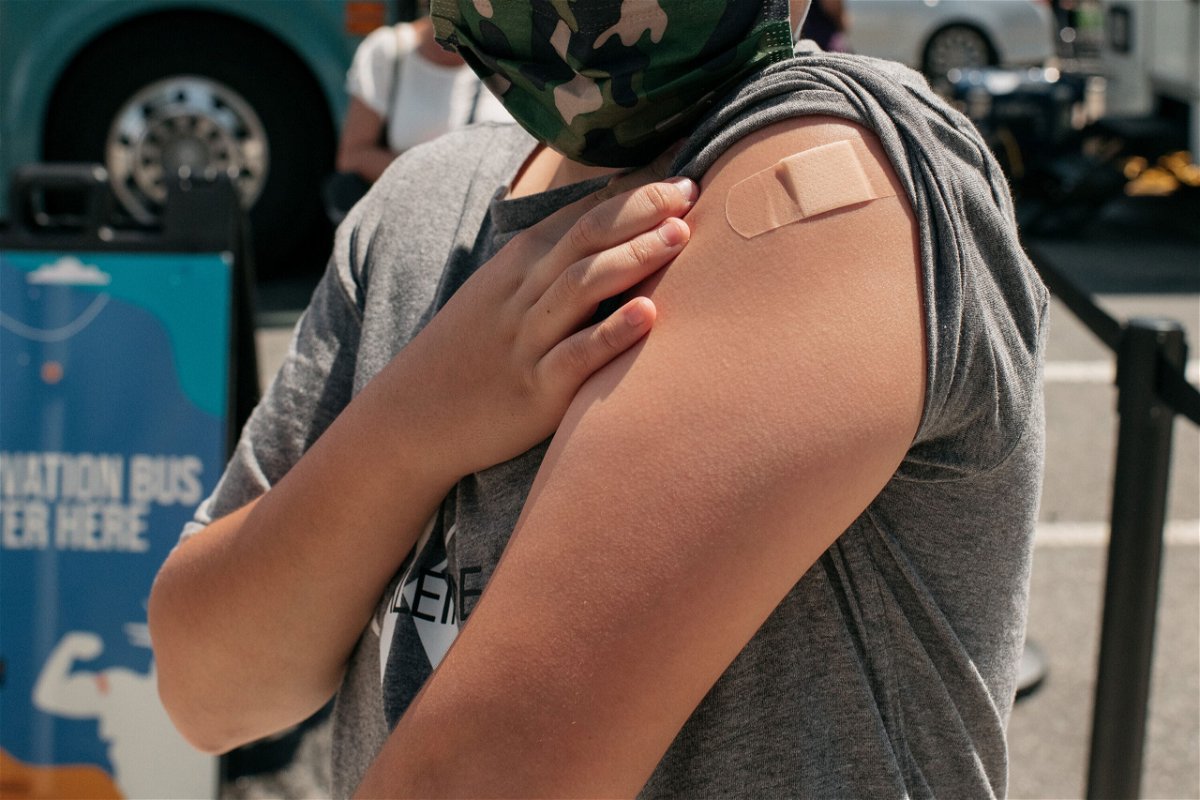 <i>Scott Heins/Getty Images</i><br/>A 13-year-old newly vaccinated against COVID-19 shows his bandage at a pop-up vaccination site on June 5