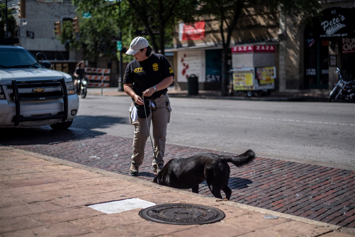 <i>Sergio Flores/Getty Images</i><br/>An officer surveys the scene of a shooting on June 12