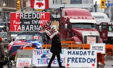 A protester walks in front of parked trucks on February 8 as demonstrators in Ottawa
