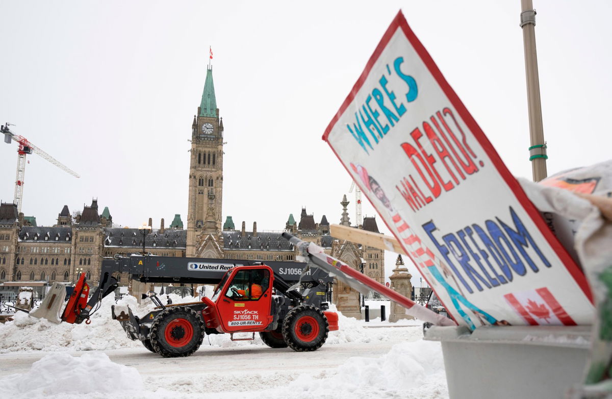 <i>Adrian Wyld/AP</i><br/>Machinery moves a concrete barricade past the Parliament buildings and a container of garbage from the trucker protest which has occupied the streets of Ottawa