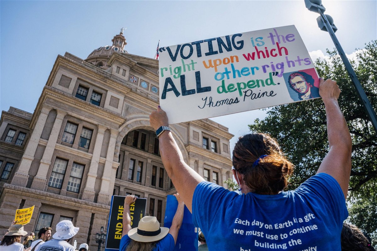 <i>Brandon Bell/Getty Images</i><br/>People display signs during the Georgetown to Austin March for Democracy rally on July 31