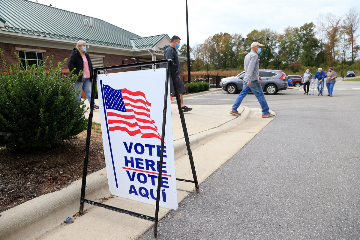<i>Brian Blanco/Getty Images</i><br/>Voters arrive and depart a polling place on October 31