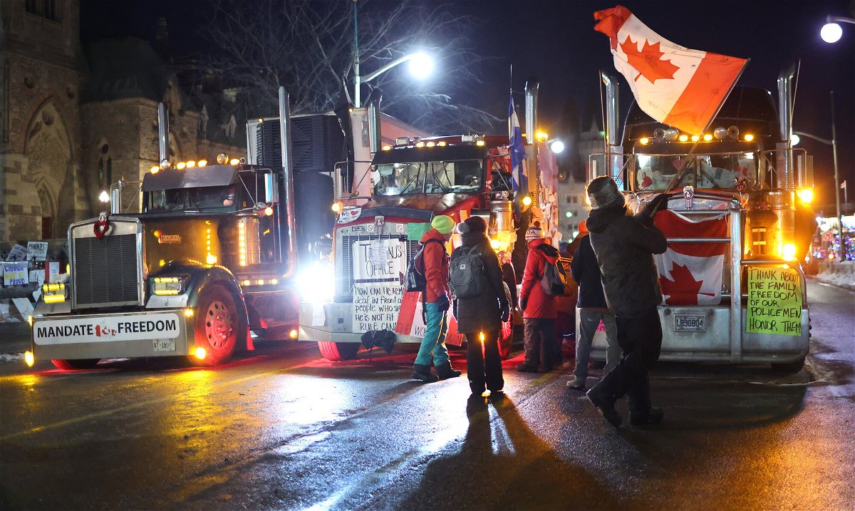 <i>Scott Olson/Getty Images</i><br/>Trucks and protestors block downtown streets near the Parliament Buildings as a demonstration led by truck drivers protesting vaccine mandates continue on February 15 in Ottawa