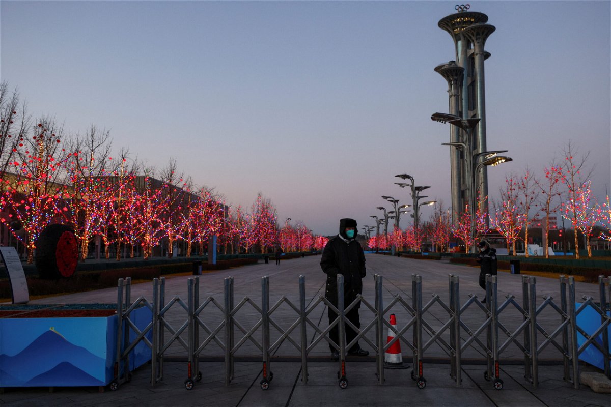 <i>Thomas Peter/Reuters</i><br/>A security guard keeps watch at the boundary of the Beijing Olympic bubble on January 25.