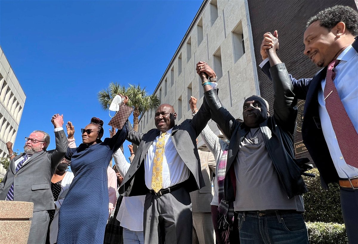 <i>Lewis M. Levine/AP</i><br/>The family of Ahmaud Arbery and attorneys raise their arms in victory Tuesday outside the federal courthouse in Brunswick