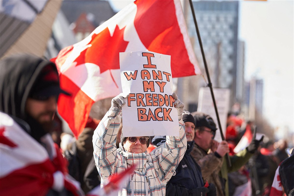<i>Geoff Robins/AFP/Getty Images</i><br/>A demonstrator holds a sign during a protest against mandates related to Covid-19 vaccines and restrictions in downtown Toronto on February 5