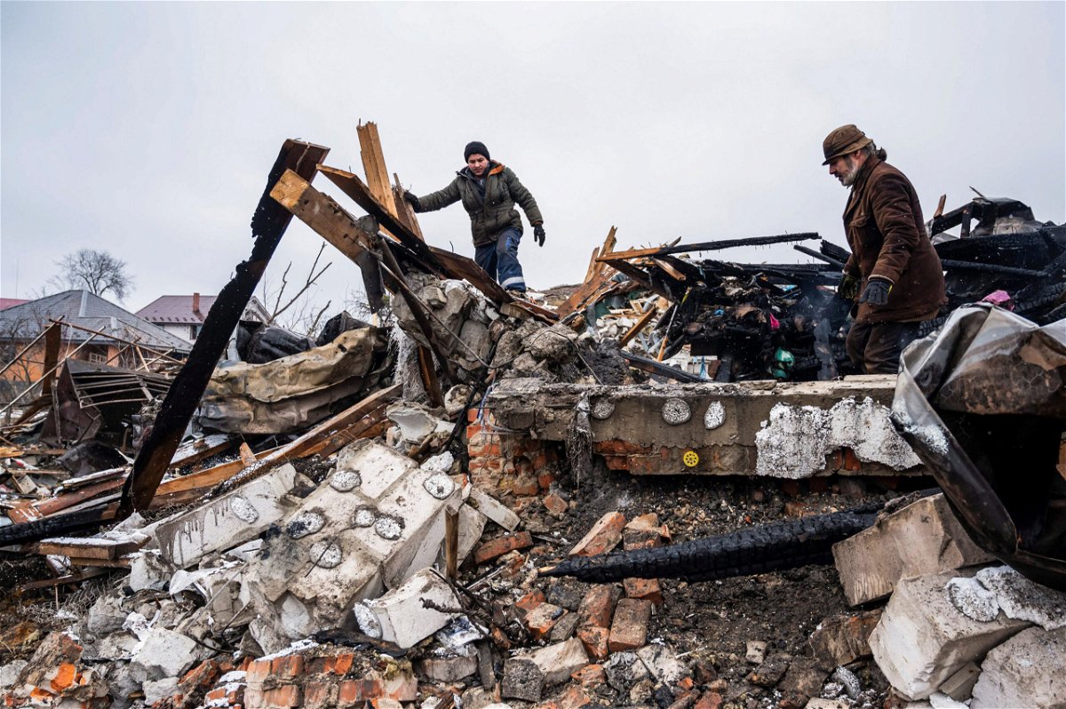 <i>Viacheslav Ratynsky/Reuters</i><br/>Local residents remove debris of a residential building destroyed by shelling