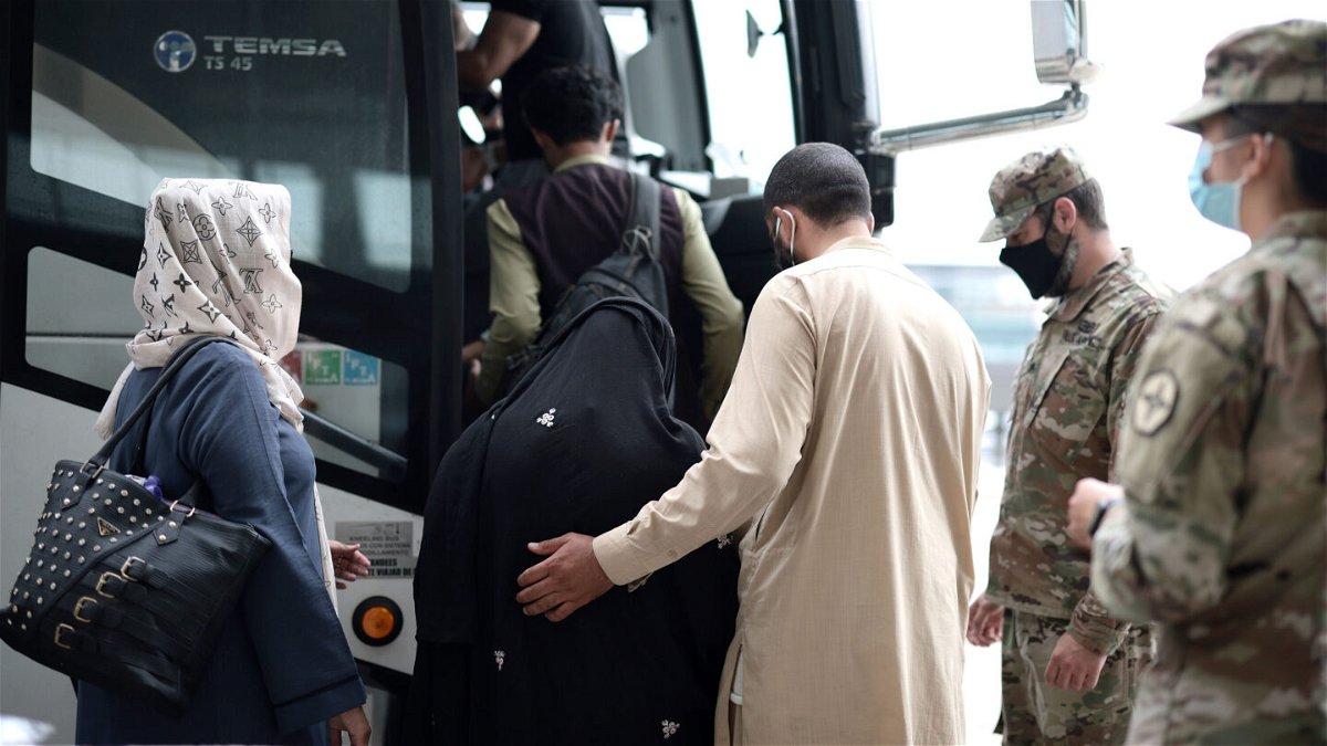 <i>Anna Moneymaker/Getty Images</i><br/>The Biden administration extends immigration relief to Afghans in the US. Afghan refugees here board a bus at Dulles International Airport on August 31