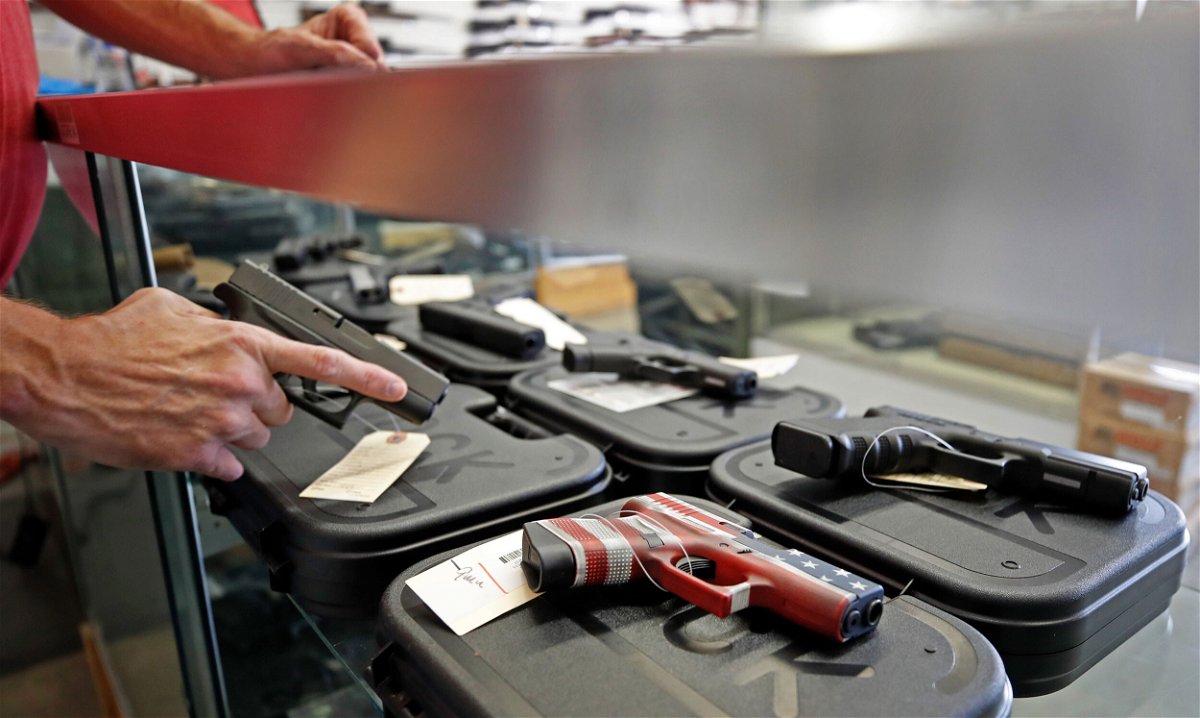 <i>George Frey/AFP/ Getty Images</i><br/>A worker restocks handguns in Orem