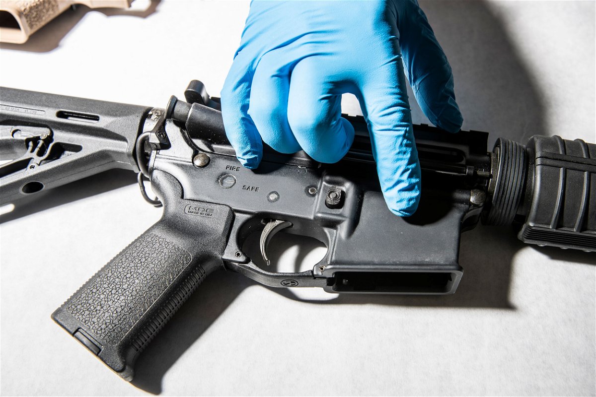 <i>Stephen Lam/The San Francisco Chronicle/Getty Images</i><br/>A police service technician with the Oakland Police Department Property and Evidence Unit points to a seized AR-15 assault rifle from a sample of ghost guns