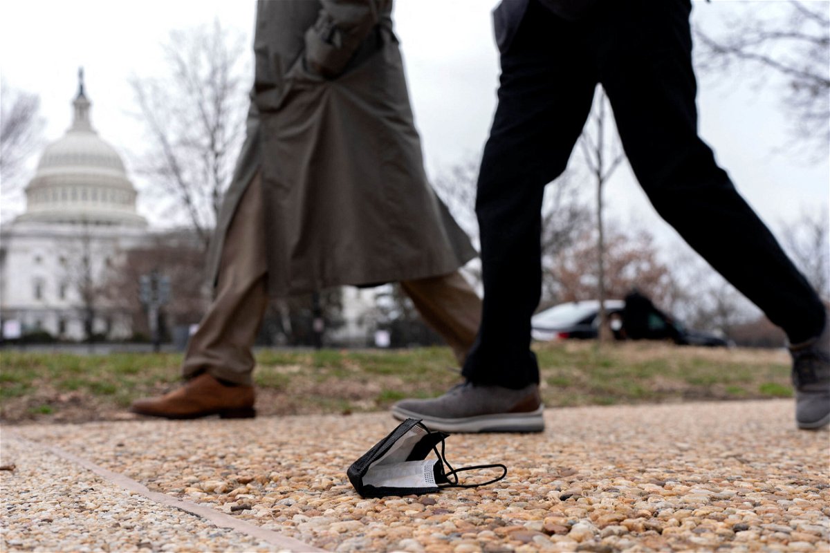 <i>Stefani Reynolds/AFP/Getty Images</i><br/>People walk past a protective face mask on the ground in Washington