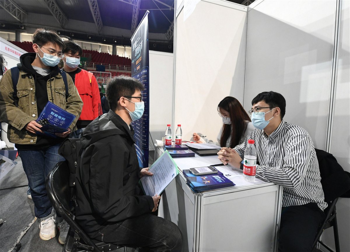 <i>Ren Chao/Xinhua/Getty Images</i><br/>A student is seen at a job fair at the Beijing Institute of Technology in October 2021. A top Chinese regulator says the country's biggest tech companies have added nearly 80