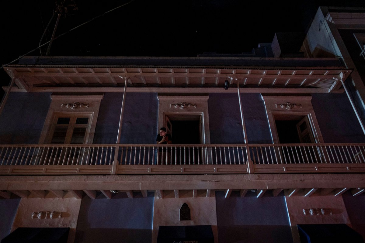 <i>Ricardo Arduengo/AFP/Getty Images</i><br/>A man stands on a balcony in San Juan