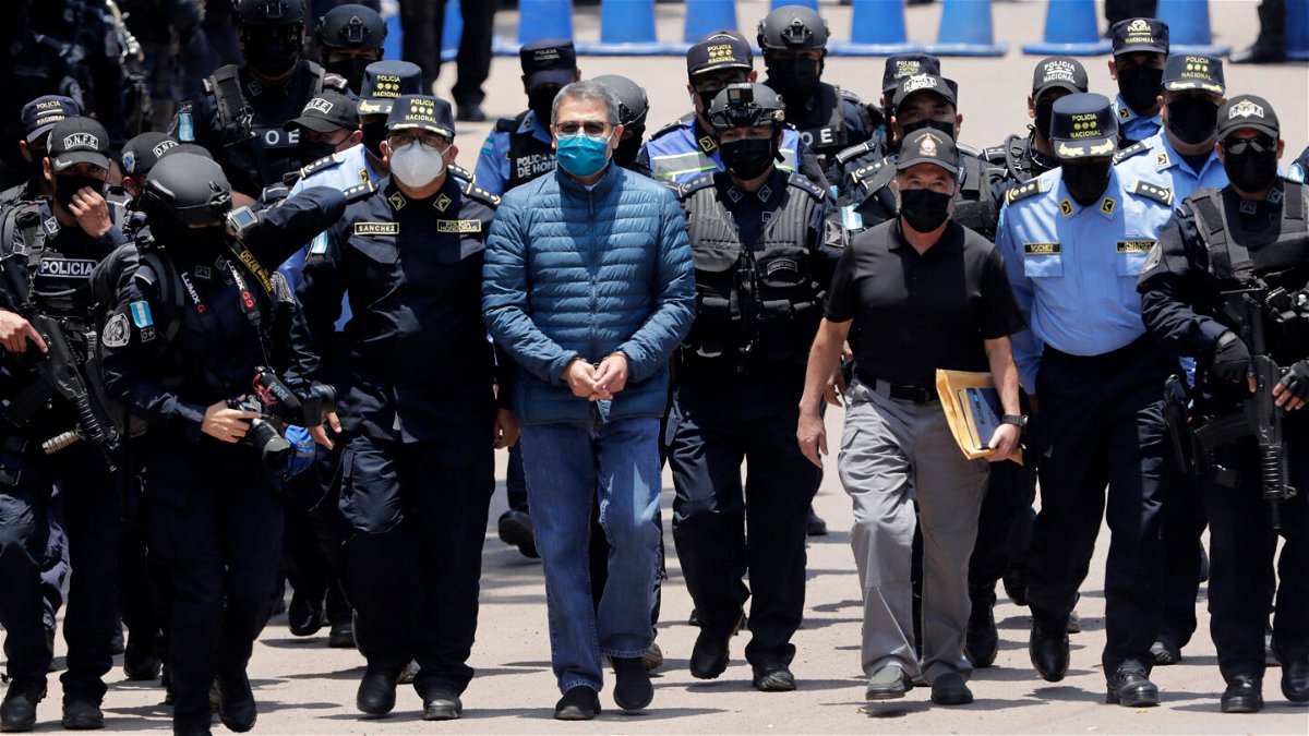 <i>Jorge Cabrera/Getty Images</i><br/>Hernández is escorted by members of the police special forces in Tegucigalpa ahead of his extradition.