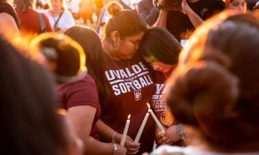 Attendees light candles during a memorial held for the 19 children and two teachers who were murdered by an 18-year-old gunman at Robb Elementary School the day before