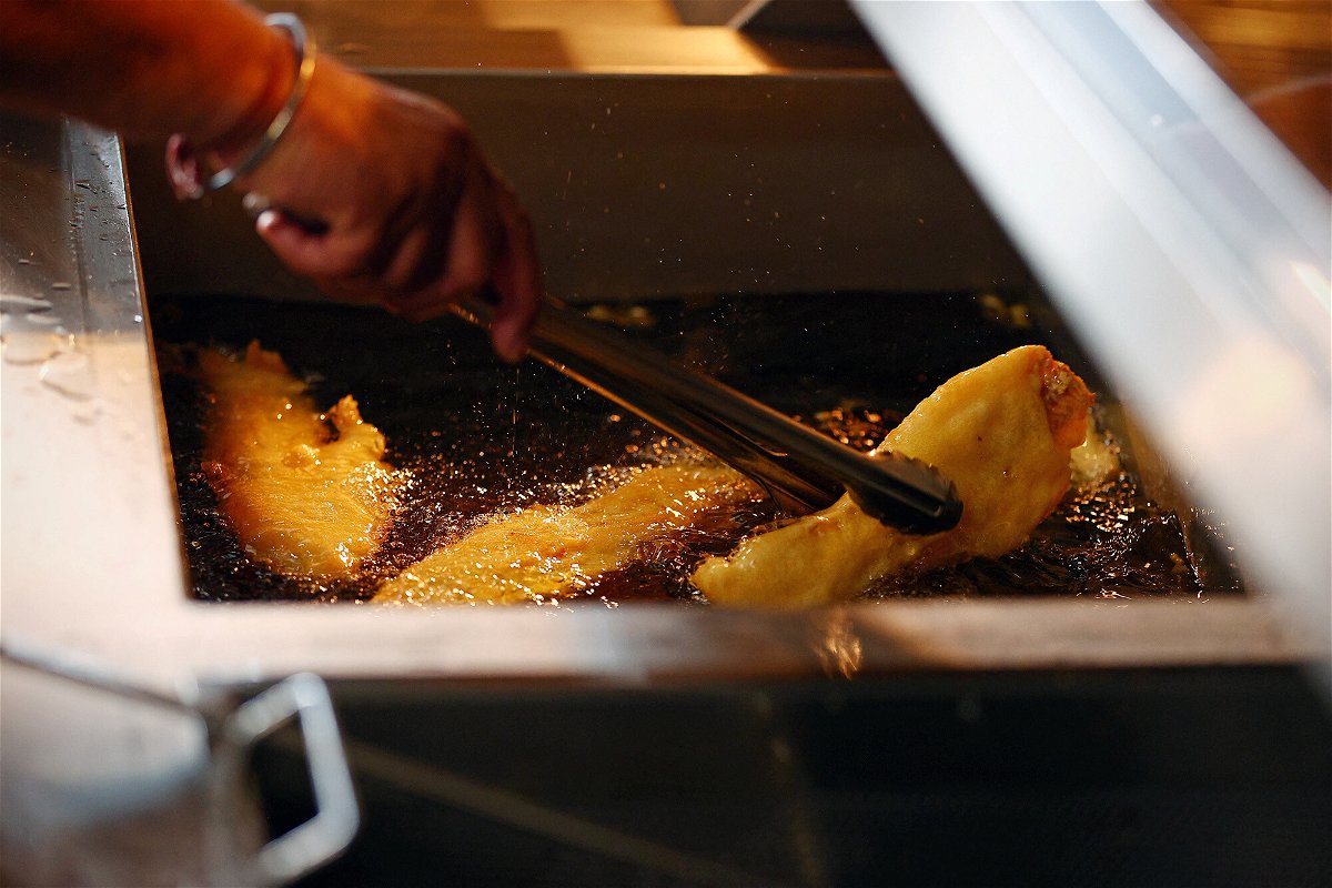 <i>Adrian Dennis/AFP/Getty Images</i><br/>A chef turns a piece of fried fish in the fryer as it gets cooked